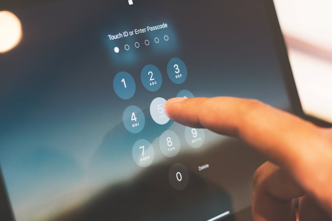 digital-01 Close-up of a finger entering a passcode on a smartphone security screen.